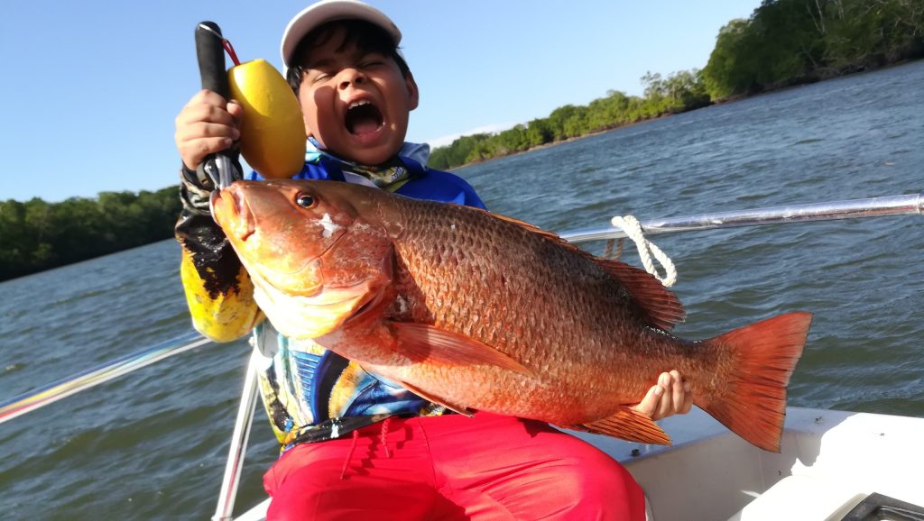 Fisherman holding a red snapper caught in the Gulf of Montijo