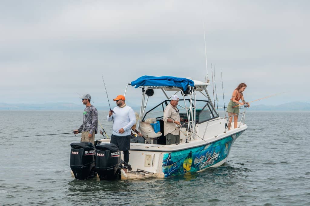 Anglers casting from a boat in open water in the Gulf of Montijo
