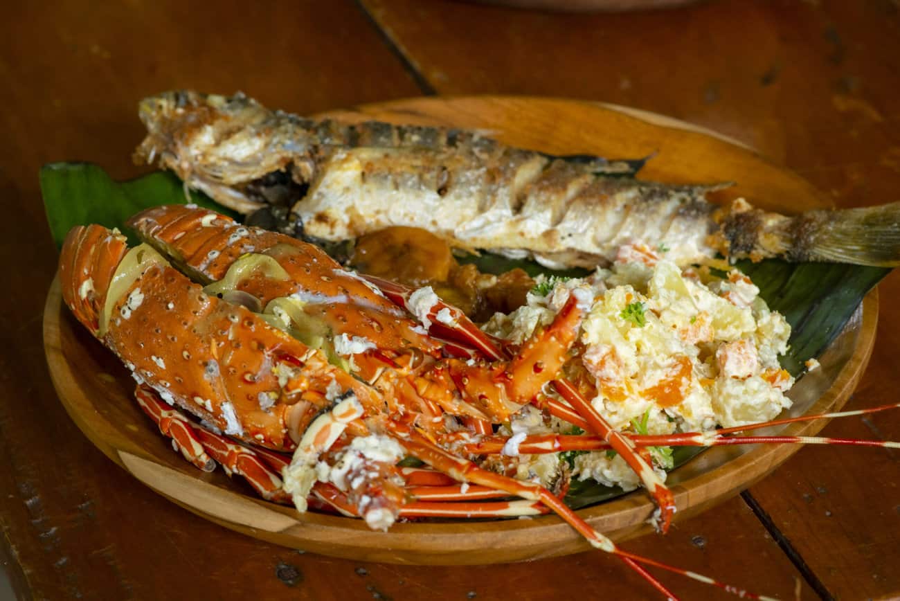 Pescado y langosta a la parrilla, platos típicos de la gastronomía marina en Pacific Adventure Tours.